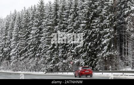 Einsiedel, Deutschland. Februar 2020. Ein Auto fährt auf einer Landstraße durch den verschneiten Wald bei Einsiedel. Kredit: Jan Woitas / dpa-Zentralbild / dpa / Alamy Live News Stockfoto