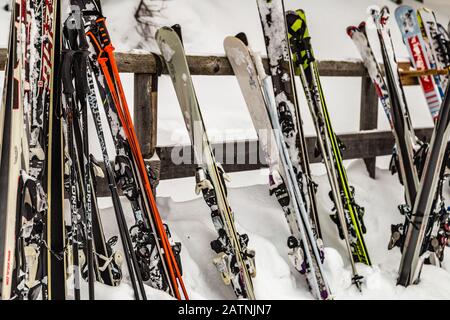 Badia (BZ), 11. FEBRUAR 2019: Licht erleuchtet gestapelte Skier auf Schnee Stockfoto