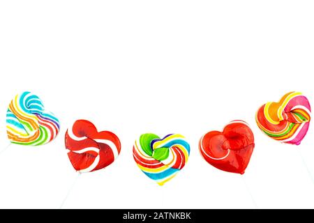Foto schöner Regenbogen herzförmige Lollipop-Süßigkeiten auf weißem Hintergrund, Valentinstag Konzept Stockfoto