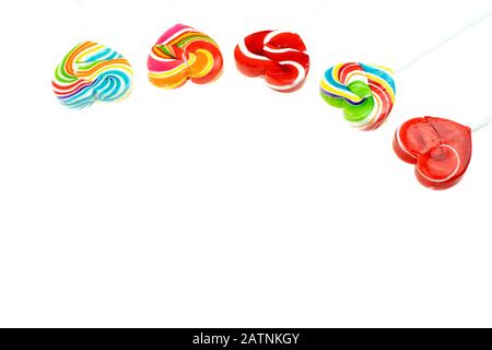 Foto schöner Regenbogen herzförmige Lollipop-Süßigkeiten auf weißem Hintergrund, Valentinstag Konzept Stockfoto