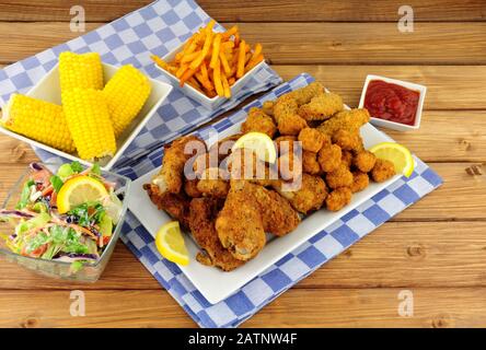 Sammlung von süßen gebratenen Hühnerprodukten mit Zuckermais und Salat Stockfoto