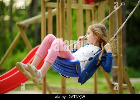 Süße kleine Mädchen Spaß haben auf einem Spielplatz im Freien im Sommer. Sport Aktivitäten für Kinder. Stockfoto