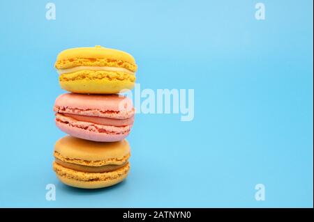 Süße französische Makronen in Pastellfarben auf blauem Hintergrund. Stockfoto