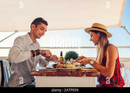 Romantisches Flitterwochen-Abendessen für zwei Personen. Ein Paar, das Essen isst und Getränke bekommt. Valentinstag im Café Stockfoto