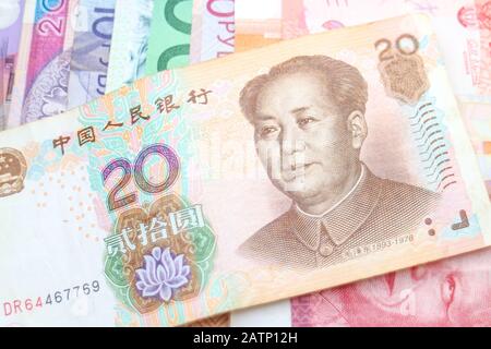 Eine chinesische Yuan-Banknote, die diagonal auf einem Regenbogen von Banknoten verschiedener Weltwährungen angeordnet ist, darunter Euro, Schekel, Rand und Polnisch Złoty. Stockfoto