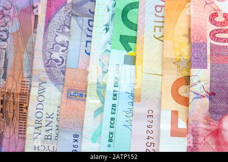 Ein Regenbogen von Banknoten verschiedener Weltwährungen, darunter Euro-Banknoten, australische Dollar, israelische Schekel, südafrikanische Rand und polnische Złoty. Stockfoto