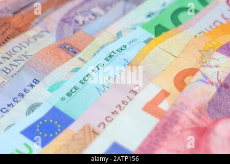 Ein Regenbogen von Banknoten verschiedener Weltwährungen, darunter Euro-Banknoten, australische Dollar, israelische Schekel, südafrikanische Rand und polnische Złoty. Stockfoto