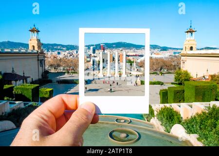 Nahaufnahme eines Mannes mit einem weißen Rahmen in der Hand, der die Vier Säulen in Montjuic Hill in Barcelona, Spanien, umrahmt und ein direktes Foto simuliert Stockfoto