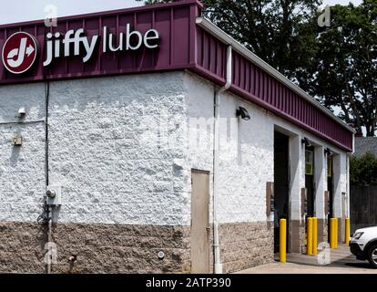 Deer Park, New York, USA - 12. Juni 2019: Eine Jiffy Lube Service-Station mit drei Buchten und einem weißen Auto, das für einen Ölwechsel einzieht. Stockfoto