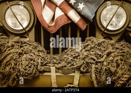 Retro-styltes Bild eines alten Armeewagens mit amerikanischer Flagge Stockfoto