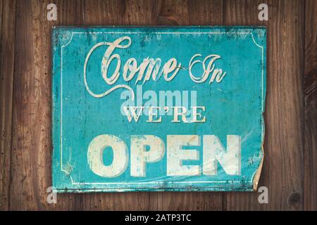 Retro hellblau kommen Sie herein wir sind offenes Schild auf einem alten Holzhintergrund Stockfoto