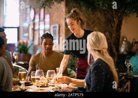 Eine Kellnerin, die Kunden in einem Restaurant in Newcastle-Upon-Tyne eine Mahlzeit serviert. Stockfoto