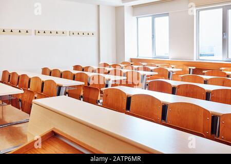 Kleines Klassenzimmer eines Universitäts-Hörsaals mit Holzschreibtischen und Sitzplätzen Stockfoto