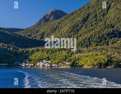 Die Fähre von Quelat verlässt das Dorf Puerto Gaviota auf der Isla Magdalena, Berge mit gemäßigtem Regenwald, Aysen Region, Patagonien, Chile Stockfoto