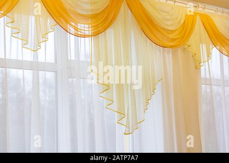 Zarte gelbe Tüllchen am Fenster, Zimmerdekor Stockfoto