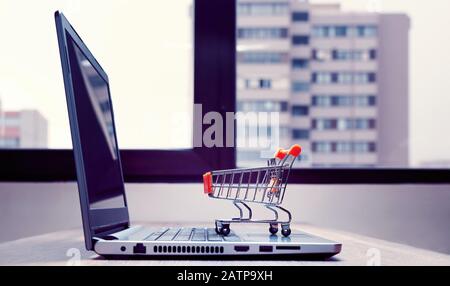 Online-Shopping-Konzept mit einem Warenkorb auf einem Laptop Stockfoto
