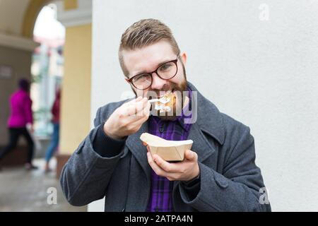 Der Mann hält Falafel-Sandwich in Papiertüte. Gesundes Straßennahrungskonzept, orientalische Küche Stockfoto