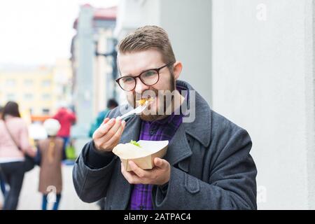 Mann mit einem Teller mit traditioneller jüdischer Speisefalafel aus Kichererbsen beim Straßennahrungsfest. Stockfoto