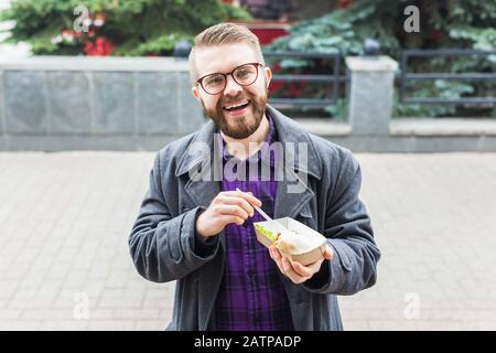 Mann mit einem Teller mit traditioneller jüdischer Speisefalafel aus Kichererbsen beim Straßennahrungsfest. Stockfoto