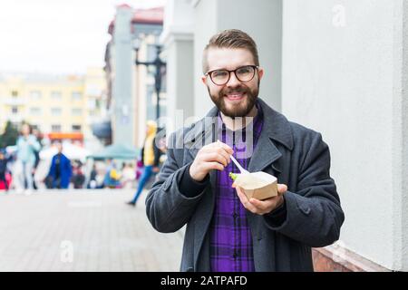 Mann mit einem Teller mit traditioneller jüdischer Speisefalafel aus Kichererbsen beim Straßennahrungsfest. Stockfoto