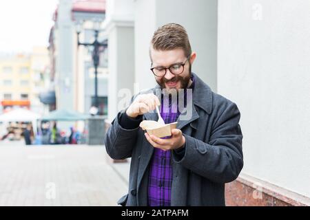 Der Mann hält Falafel-Sandwich in Papiertüte. Gesundes Straßennahrungskonzept, orientalische Küche Stockfoto