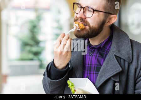 Mann mit einem Teller mit traditioneller jüdischer Speisefalafel aus Kichererbsen beim Straßennahrungsfest. Stockfoto