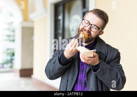 Mann mit einem Teller mit traditioneller jüdischer Speisefalafel aus Kichererbsen beim Straßennahrungsfest. Stockfoto