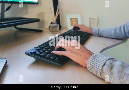 Frau, die auf der drahtlosen Tastatur tippt Stockfoto