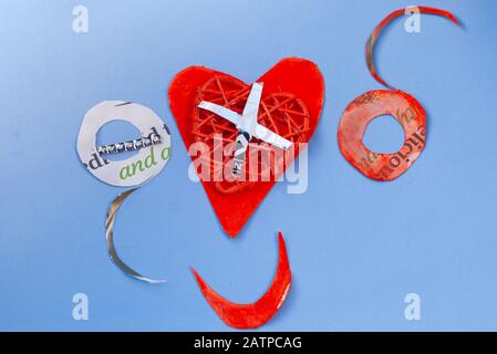 Still Life Love Konzept für Valentines Day - OXO und rotes Papier Herz & lächelnder Mund auf hellblauem Hintergrund. Copyspace. Stockfoto