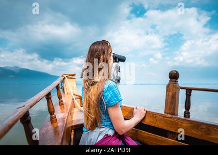 Frau auf einem Boot mit binokulären beobachtbaren Vögeln Stockfoto