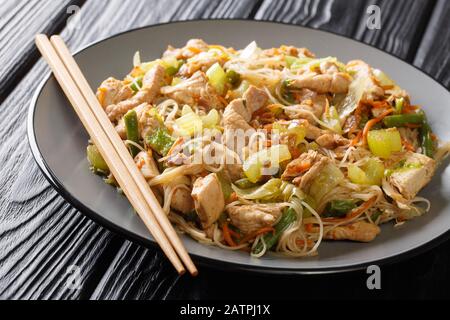 Traditionelle philippinische Nudeln pancit bichon mit Gemüse und Fleisch in einer würzigen Sauce in einer Platte auf dem Tisch. Horizontal Stockfoto