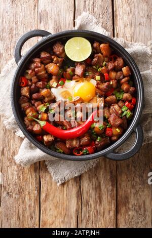 Sisig ist ein philippinisches Gericht aus Teilen von Schweinekopf und Hühnerleber, das normalerweise mit Zwiebeln und Chilischoten in einer Pfanne auf dem Tisch gewürzt wird. Stockfoto