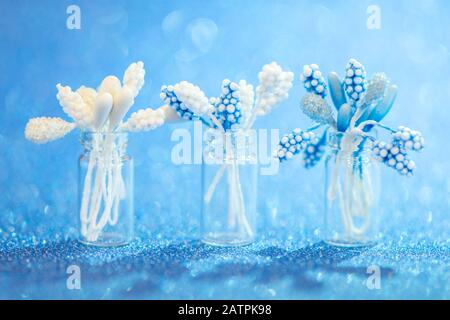 Nahaufnahme künstlicher Blumen in einer Glasvase auf blauem unscharfen Hintergrund für den Valentinstag Stockfoto