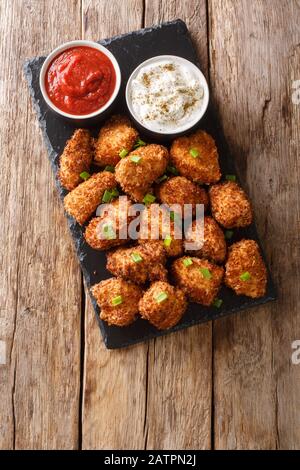 Kokosnussgepanste Hühnchennuggets mit Ketchup und Mayonnaise Nahaufnahme auf einem Schieferbrett auf einem Tisch serviert. Vertikale Draufsicht von oben Stockfoto