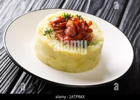 Leckere Trinxat Kartoffelpüree und Grünkohl mit gebratenem Speck in einem Teller auf dem Tisch. Horizontal Stockfoto