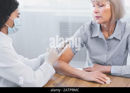 Latina Doktor geimpft ältere Frau Stockfoto