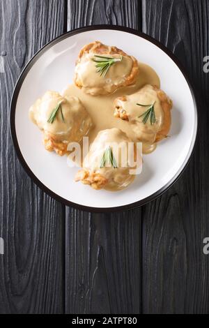 Hühnerschenkel in einer Sauce aus Dijon-Senf und Ahorn-Sirup in einer Platte in der Nähe des Tisches. Vertikale Draufsicht von oben Stockfoto