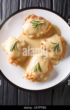 Holy Yum Chicken Oberschenkel in Senf-Ahorn-Sauce in einem Teller auf dem Tisch. Vertikale Draufsicht von oben Stockfoto