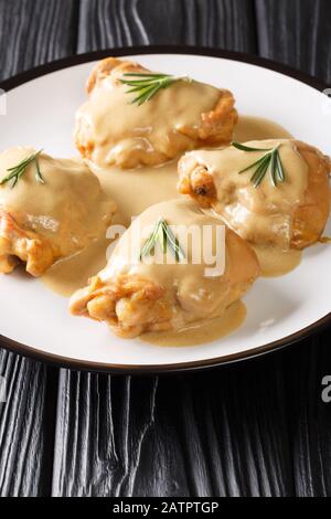 Huhn Oberschenkel in einer Sauce aus Dijon-Senf und Ahorn-Sirup in einer Platte, die auf dem Tisch liegt. Vertikal Stockfoto