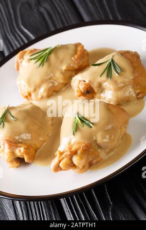 Holy Yum Chicken thighs in Senf-Ahorn-Sauce in einer Platte auf dem Tisch. Vertikal Stockfoto