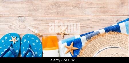 Flip-Flops, Strohhut, Seesterne, Sonnenschutzflasche, Body Lotion Spray auf Holzhintergrund Top View Banner. Flach legen Sommer Strand Meer Accessoires zurück Stockfoto