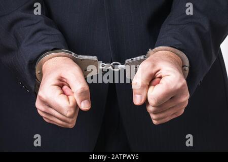Ein Mann in Anzug und Handschellen, Nahaufnahme. Haftkonzept Stockfoto