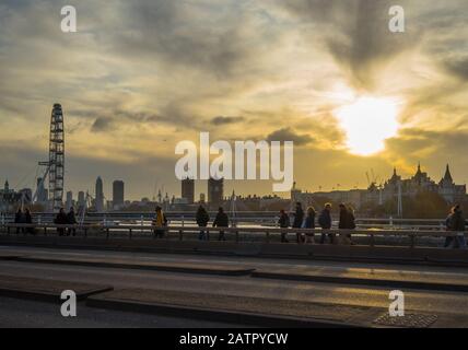 Das London Eye und die Houses of Parliament bei Sonnenuntergang von der Waterloo Bridge aus gesehen. London Stockfoto
