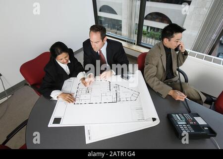 Blick auf Geschäftsleute Überprüfung Bauplan mit einem Architekten sprechen am Telefon. Stockfoto