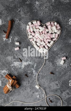 Ein herzförmiges weißes Garn voller Marshmallows für den Valentinstag, den 14. Februar Stockfoto