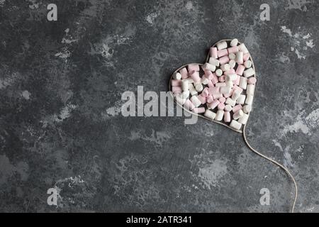 Ein herzförmiges weißes Garn voller Marshmallows für den Valentinstag, den 14. Februar Stockfoto