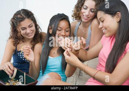 Vier Mädchen im Teenageralter Auswahl Schmuck und lächelnd Stockfoto