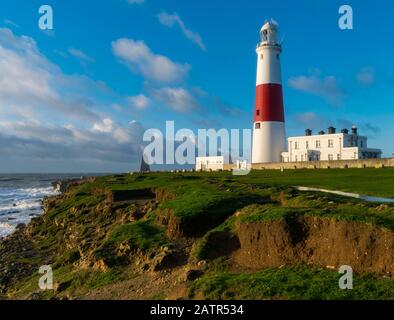 Portland Bill Leuchtturm an der Jurassic Küste an einem sonnigen Morgen Beleuchtung der Portland Steinklippen mit dem Meer und Wellen im Blick Stockfoto