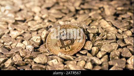 Goldene Bitcoin-Münze auf einem Stapel goldener Nuggets. Blockchain Cryptocurrency, Wertspeicher. Digitales Goldkonzept. Stockfoto