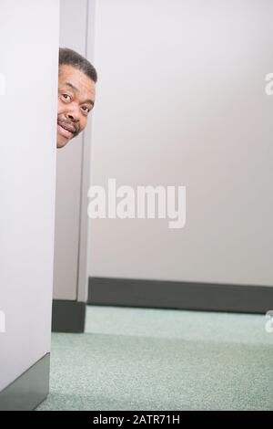 Porträt eines Geschäftsmannes spähen durch eine Kabine Stockfoto